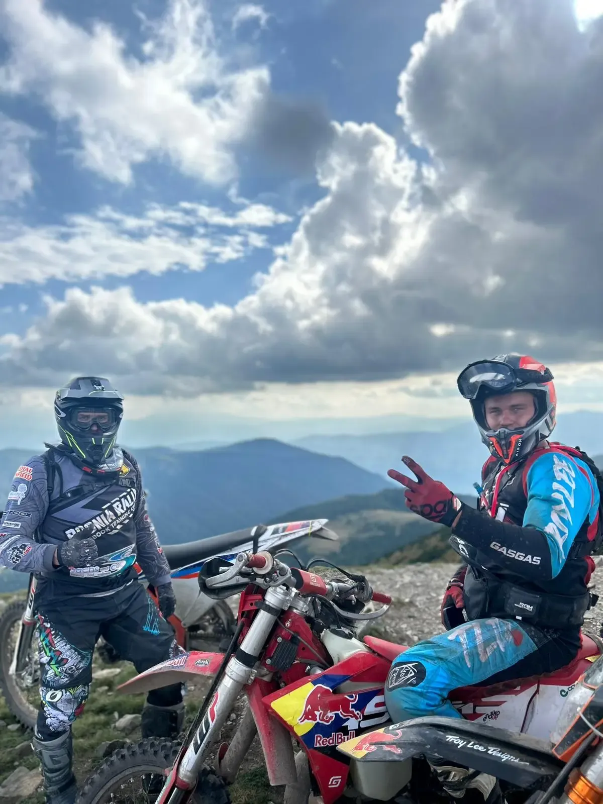 Zwei Enduro-Fahrer in Schutzausrüstung vor einem Bergpanorama